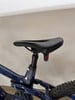 Sattel eines dunkelblauen Mountainbikes mit rotem Reflektor.