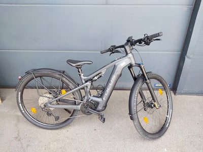 Graues Focus E-Bike mit Schutzblechen und Gepäckträger vor grauem Hintergrund. Graues Focus E-Bike mit Schutzblechen und Gepäckträger vor grauem Hintergrund.