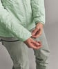 Detail einer Jacke und Händen einer Frau in einer Daunenjacke und Hose.