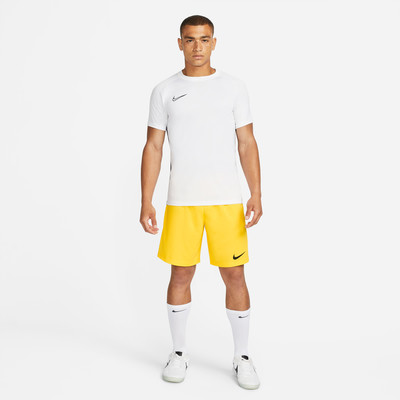 Mann in weißem T-Shirt und gelber Nike-Shorts mit Logo. Mann in weißem T-Shirt und gelber Nike-Shorts mit Logo.