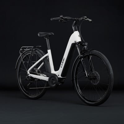 Modernes weißes E-Bike mit schwarzen Details und Gepäckträger vor schwarzem Hintergrund. Modernes weißes E-Bike mit schwarzen Details und Gepäckträger vor schwarzem Hintergrund.