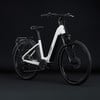 Modernes weißes E-Bike mit schwarzen Details und Gepäckträger vor schwarzem Hintergrund.