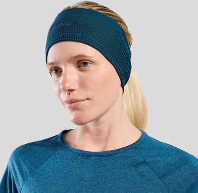Eine Frau trägt ein blaues Stirnband und ein T-Shirt, Nahaufnahme von Gesicht und Schultern.