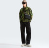 Ein Mann im Camouflage-Fleecepullover und schwarzer Cargohose mit Bauchtasche.