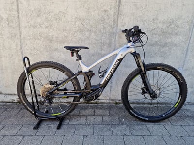 Silbernes Genesis E-Bike auf einem Ständer vor einer Betonwand. Silbernes Genesis E-Bike auf einem Ständer vor einer Betonwand.