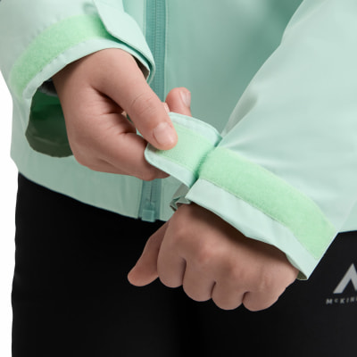 Eine Hand schließt den Klettverschluss am Ärmel der Jacke.