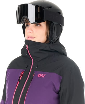 Eine Frau in einem Skianzug mit lila und schwarzen Elementen.