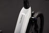 Detail eines weißen E-Bikes mit der Aufschrift TOURING und Vorderradgabel.