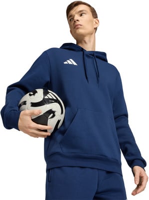 Ein junger Mann in einem dunkelblauen Kapuzenpullover hält einen Fußball. Ein junger Mann in einem dunkelblauen Kapuzenpullover hält einen Fußball.