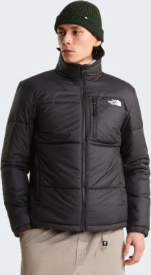 Ein Mann in einer schwarzen Daunenjacke und grüner Mütze blickt zur Seite. Ein Mann in einer schwarzen Daunenjacke und grüner Mütze blickt zur Seite.