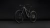 Modernes Mountain-E-Bike mit Federung auf dunklem Hintergrund.