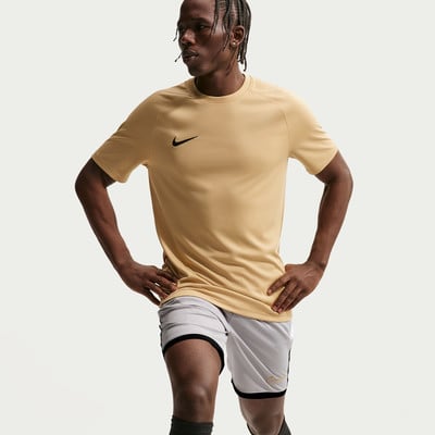 Ein Mann in einem beigefarbenen T-Shirt und hellgrauen Shorts mit schwarzem Besatz. Ein Mann in einem beigefarbenen T-Shirt und hellgrauen Shorts mit schwarzem Besatz.