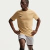 Ein Mann in einem beigefarbenen T-Shirt und hellgrauen Shorts mit schwarzem Besatz.