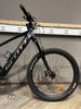 Schwarzes Scott E-Mountainbike mit Federgabel und Maxxis-Felge.