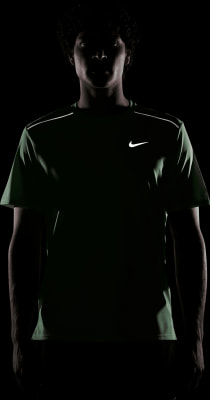 Mann in dunkelgrünem T-Shirt mit Nike-Logo und Reflexstreifen.