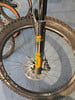 Detail eines Mountainbikes mit Federung und Scheibenbremse.