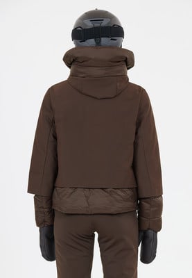Rückansicht einer Person in brauner Skijacke, Helm und Handschuhen. Rückansicht einer Person in brauner Skijacke, Helm und Handschuhen.