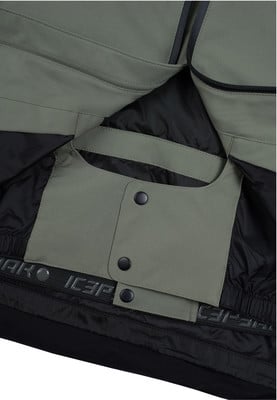Detail einer Innentasche mit Druckknöpfen auf grüner und schwarzer Kleidung.