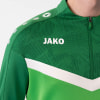 Detail einer JAKO Jacke mit Reißverschluss und Logo auf grünem Hintergrund.