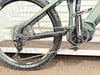 Grünes Mountain-E-Bike mit Rädern, Kette und Pedalen.