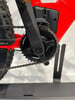 Nahaufnahme der Kurbeln und Kette eines E-Bikes mit rotem Rahmen.