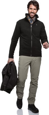 Ein Mann in schwarzer Jacke und beiger Hose hält eine schwarze Jacke in der Hand. Ein Mann in schwarzer Jacke und beiger Hose hält eine schwarze Jacke in der Hand.