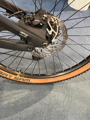 Hintere Scheibenbremse und Mountainbike-Rad mit braunem Reifen. Hintere Scheibenbremse und Mountainbike-Rad mit braunem Reifen.