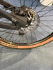 Hintere Scheibenbremse und Mountainbike-Rad mit braunem Reifen.