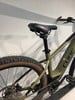 Grünes Mountain-E-Bike mit schwarzem Sattel und braunen Reifen.