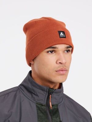 Ein Mann in einer orangefarbenen Mütze mit Logo und dunkler Jacke.