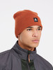 Ein Mann in einer orangefarbenen Mütze mit Logo und dunkler Jacke.