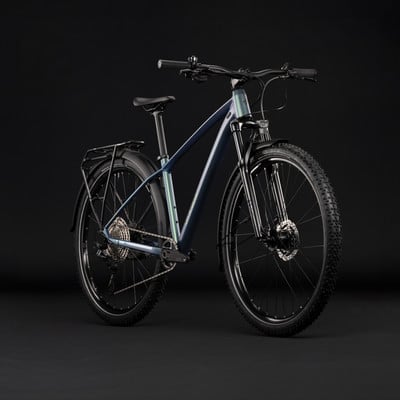 Mountainbike mit Schutzblechen und Gepäckträger vor dunklem Hintergrund.