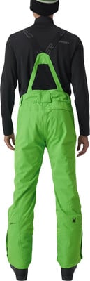 Rückansicht eines Mannes in leuchtend grüner Skihose mit Latz. Rückansicht eines Mannes in leuchtend grüner Skihose mit Latz.