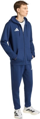 Ein Mann im dunkelblauen Adidas Trainingsanzug mit weißem Logo und Turnschuhen. Ein Mann im dunkelblauen Adidas Trainingsanzug mit weißem Logo und Turnschuhen.
