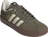 Grüner Herrenschuh von Adidas mit drei weißen Streifen und brauner Sohle.