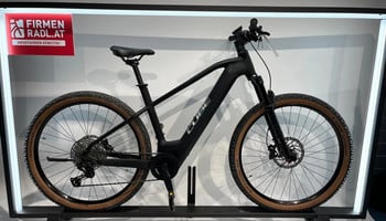 Schwarzes Cube E-Bike auf einem Ständer mit der Aufschrift „FIRMEN RADL.AT“.