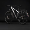 Silbernes Cube Mountainbike mit Schutzblechen und Gepäckträger vor schwarzem Hintergrund.