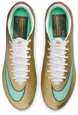 Goldene Nike Fußballschuhe mit türkisfarbenem Logo und Schriftzügen. Goldene Nike Fußballschuhe mit türkisfarbenem Logo und Schriftzügen.