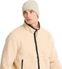 Ein Mann trägt eine cremefarbene Fleecejacke und eine Mütze.