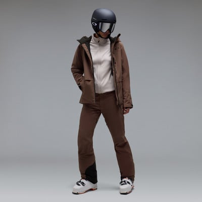Skifahrerin in brauner Jacke, Hose, Helm und Skibrille. Skifahrerin in brauner Jacke, Hose, Helm und Skibrille.