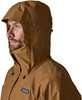 Mann in brauner Jacke mit Kapuze und Patagonia-Logo auf der Brust.