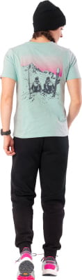 Mann in mintgrünem T-Shirt mit Berg- und Skifahrerdruck, schwarzer Jogginghose und Turnschuhen. Mann in mintgrünem T-Shirt mit Berg- und Skifahrerdruck, schwarzer Jogginghose und Turnschuhen.