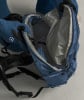 Eine Person zieht einen blauen Rucksack mit gepolsterten Trägern und Innenfutter an.