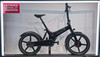 Ein schwarzes GoCycle-Elektrofahrrad steht mit einem Schild links ausgestellt.