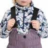 Kind in einem Overall mit einem Fleece-Pullover mit Bergedruck.