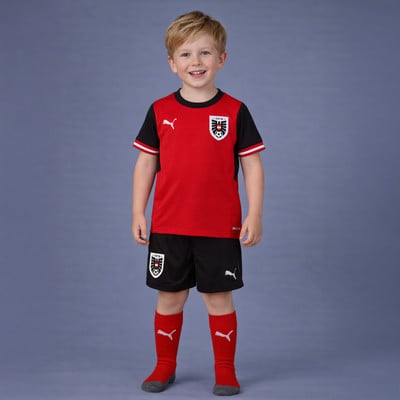 Junge in einem roten Fußballtrikot von Österreich mit schwarzen Ärmeln und Shorts. Junge in einem roten Fußballtrikot von Österreich mit schwarzen Ärmeln und Shorts.