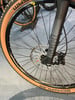 Nahaufnahme eines Mountainbikes mit braunem Reifen und RockShox-Federgabel.