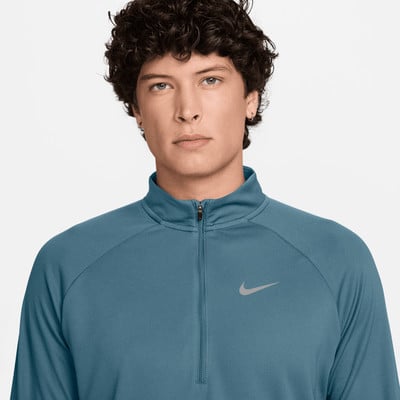 Ein Mann in einem blauen Nike-Sportpullover mit halbem Reißverschluss. Ein Mann in einem blauen Nike-Sportpullover mit halbem Reißverschluss.