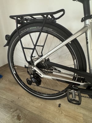 Rückseite eines silbernen Fahrrads mit Gepäckträger, Schaltwerk und Pedal. Rückseite eines silbernen Fahrrads mit Gepäckträger, Schaltwerk und Pedal.