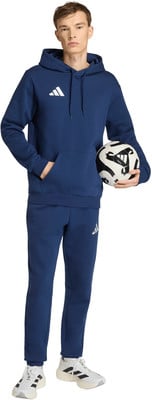 Ein junger Mann im dunkelblauen Trainingsanzug hält einen Fußball. Ein junger Mann im dunkelblauen Trainingsanzug hält einen Fußball.